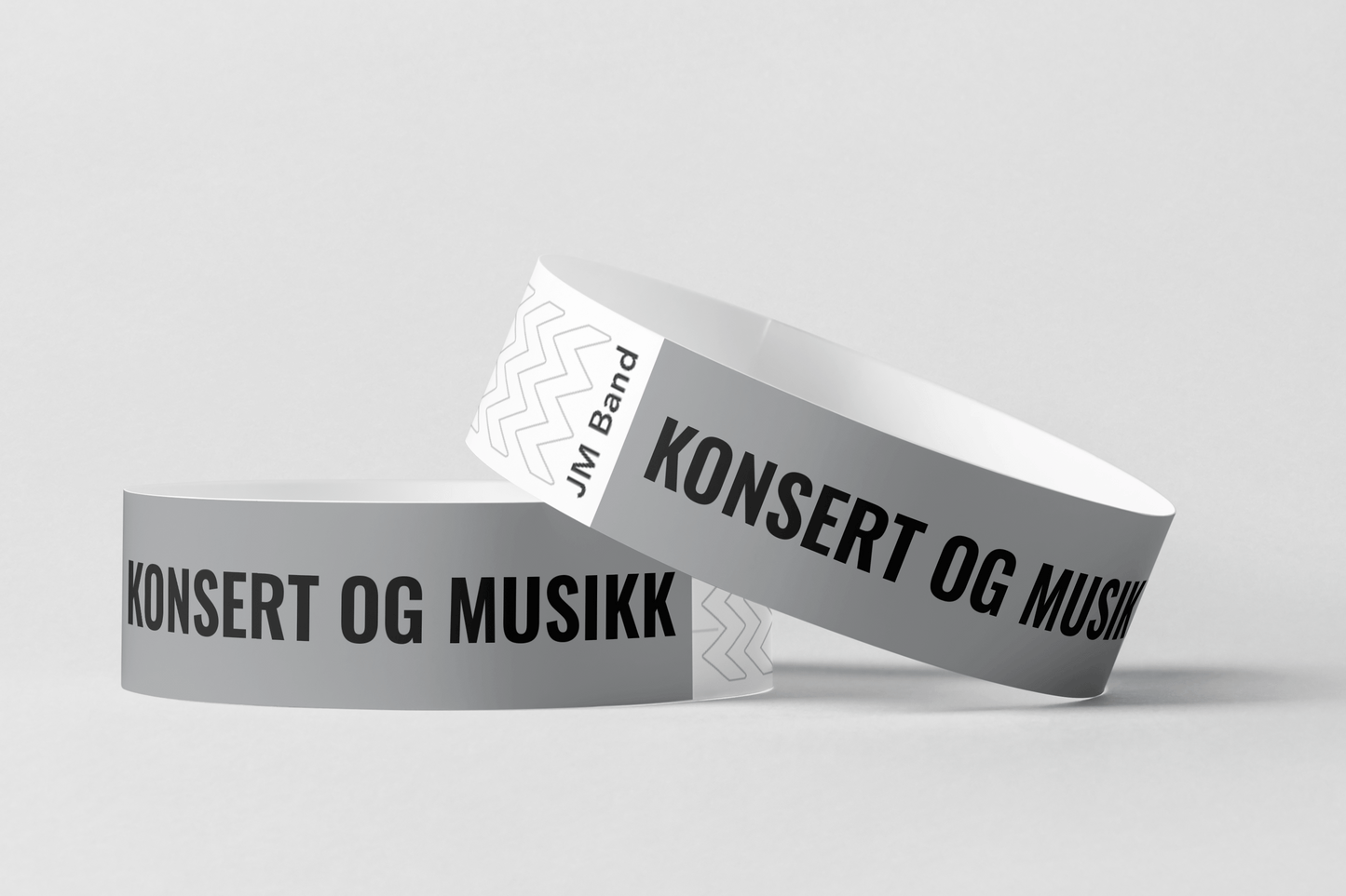 To Papirarmbånd med trykk Via e-post fra JM Band NO med ordene konsert og tyvek armbånd.