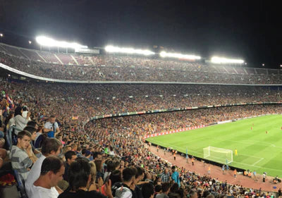 En stadion full av folk som ser på en fotballkamp.