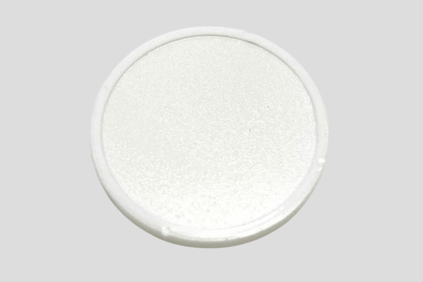 En hvit oval knapp på en grå overflate, laget av plast, kalt JM Band®s "Poletter plast preget På lager".