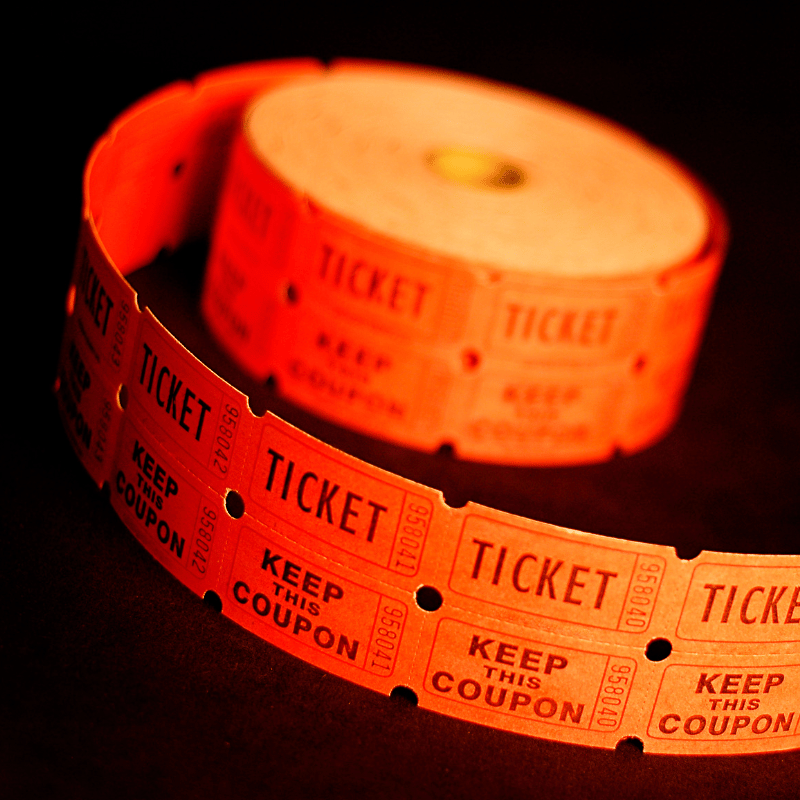 En rull med oransje billettpapir på svart bakgrunn.