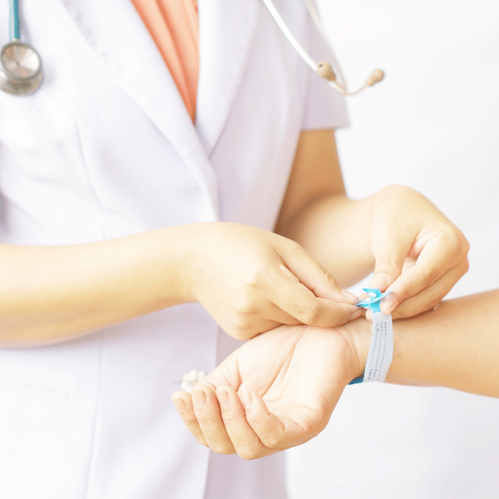 En lege legger en bandasje på en pasients håndledd.