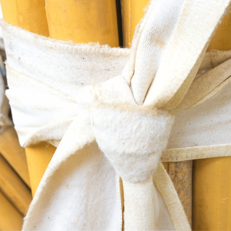Nærbilde av en hvit klut viklet rundt et par trepinner.