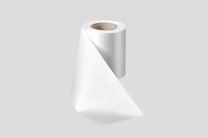 En rull hvit ECO satengbåndruller 100mm på grå bakgrunn, klar for innvielse eller pyntet med et JM Band®.