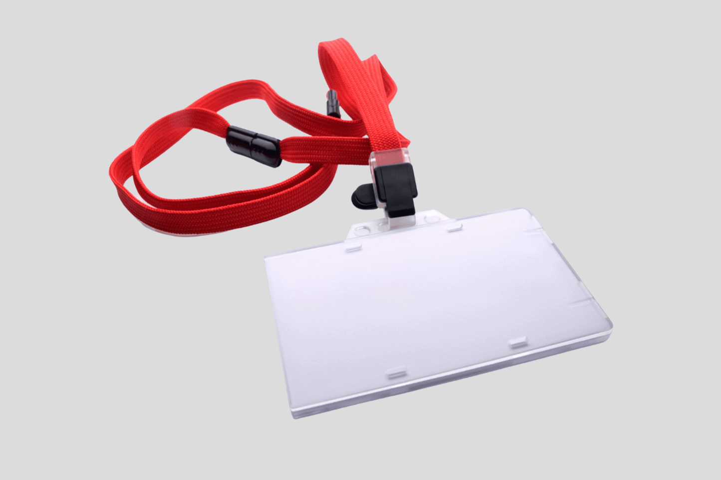 En JM Band NO Hard PVC-kortholder med en rød snor festet til.