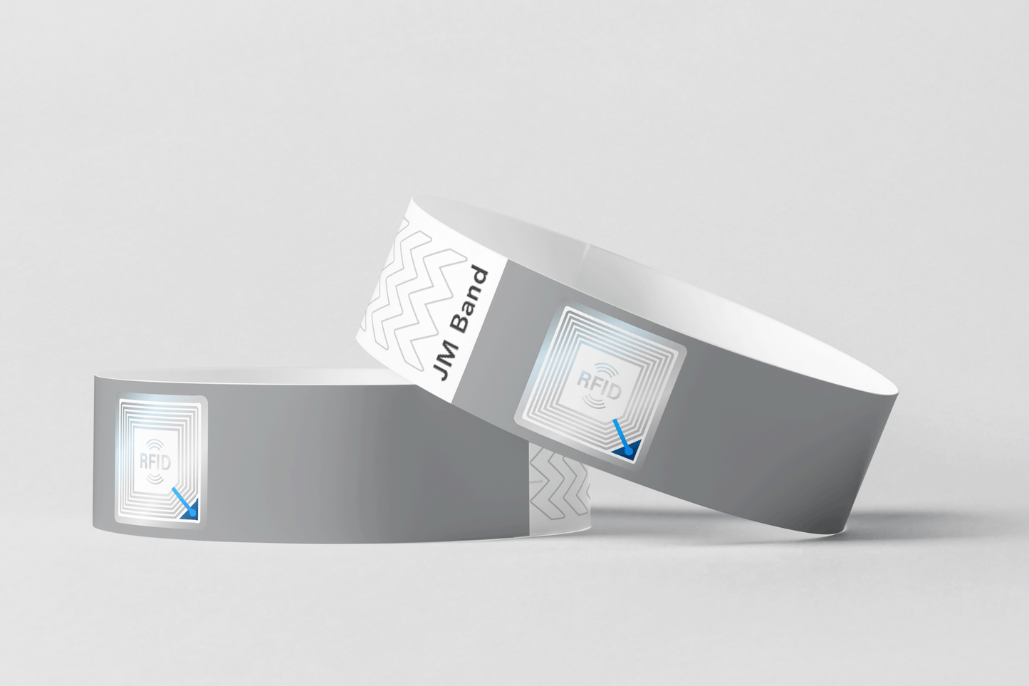 Et par grå RFID-papir armbånd med blå pil på fra JM Band NO.