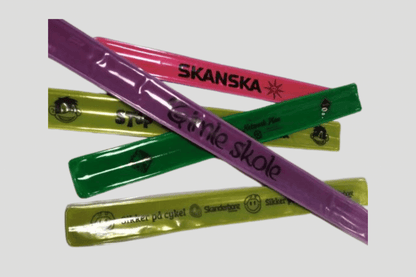 En gruppe fargerik plast Slap armbånd trykk laget av PVC-materiale, hver prydet med ordet JM Band NO silketrykt på dem.