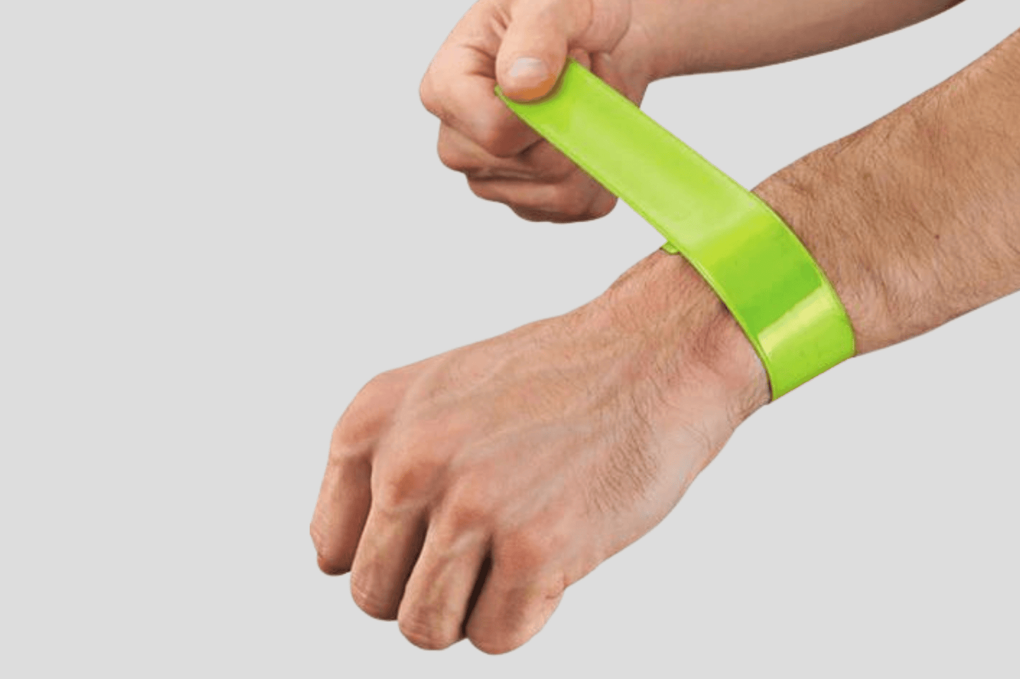 En mann holder et JM Band NO Slap armbånd trykk Via e-post laget av PVC-materiale.