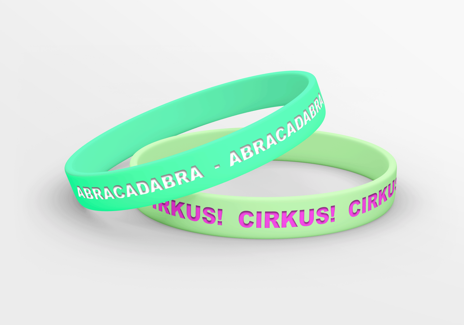Et par grønne og rosa armbånd med ordene abracadabra circus circus.