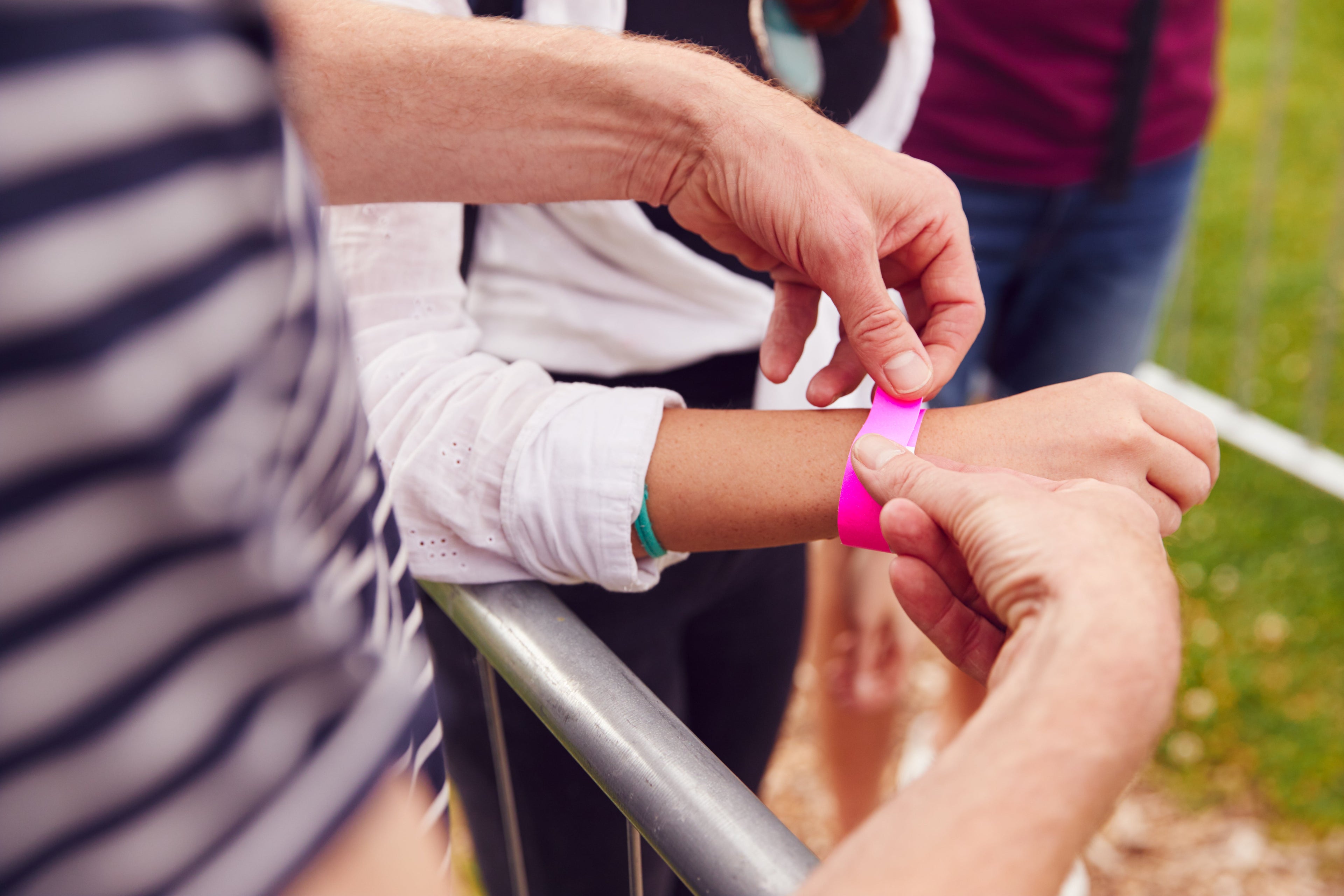 En person setter et armbånd på noens håndledd.