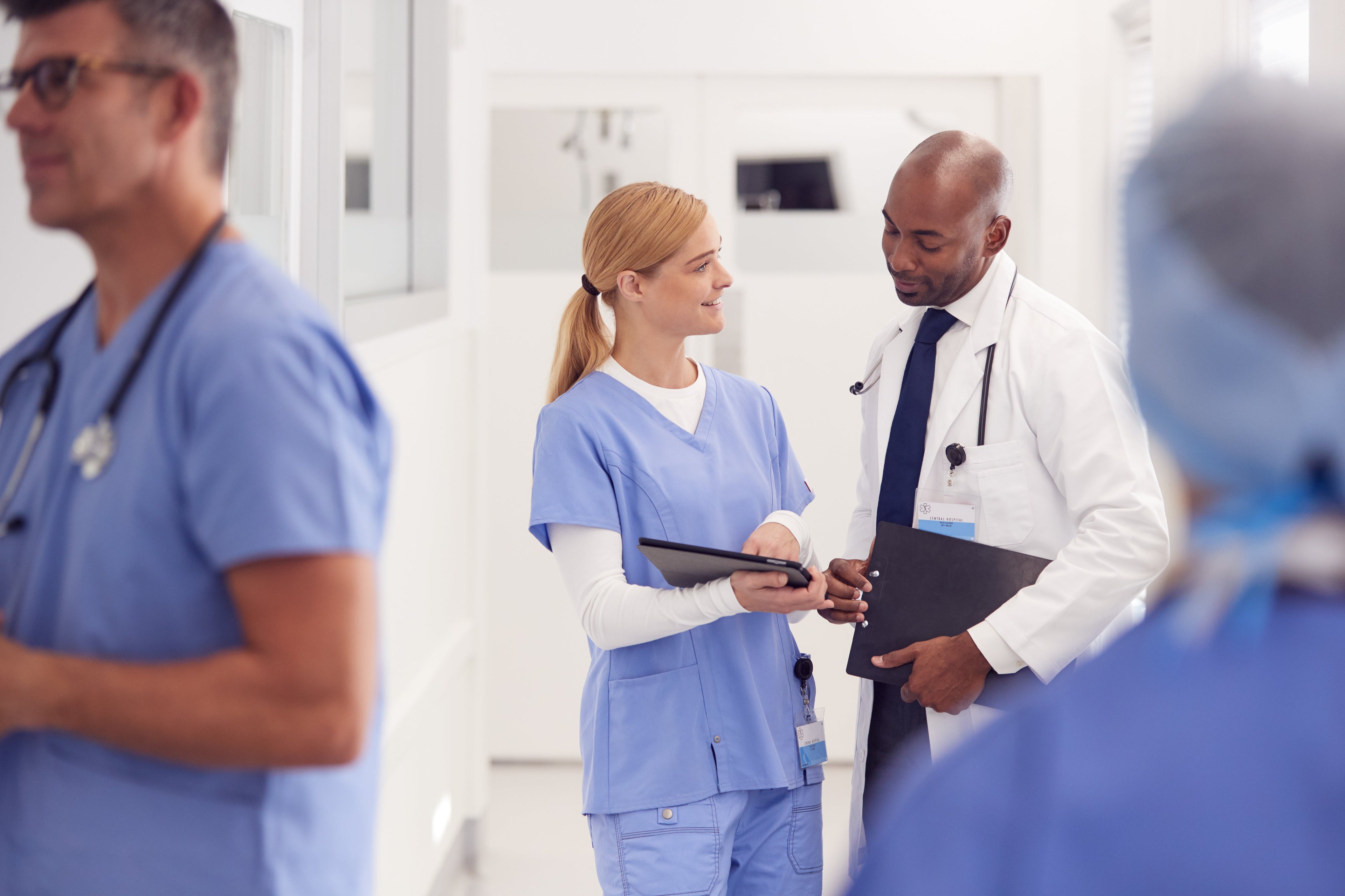 En gruppe leger og sykepleiere snakker i en sykehusgang.