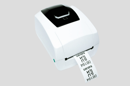 En JM Band NO Trykksystem JMB4+ etikettskriver, ved hjelp av termisk trykkteknologi, på grå bakgrunn.