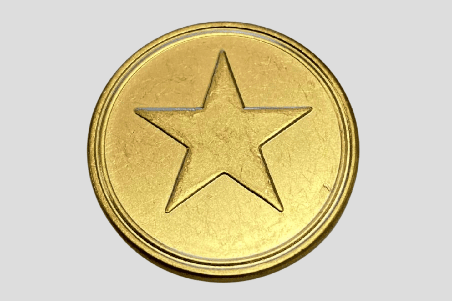 En gullstjerne på hvit bakgrunn, pyntet med plastpoletter eller skapmynter, med Poletter metall preget På lager av JM Band NO.