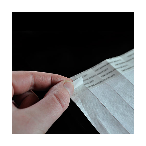 En persons hånd som holder et stykke papir.
