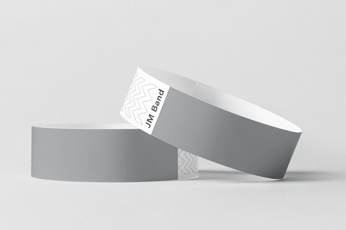 Et par grå armbånd, Papir armbånd uten trykk på lager, av JM Band NO, på hvit bakgrunn.