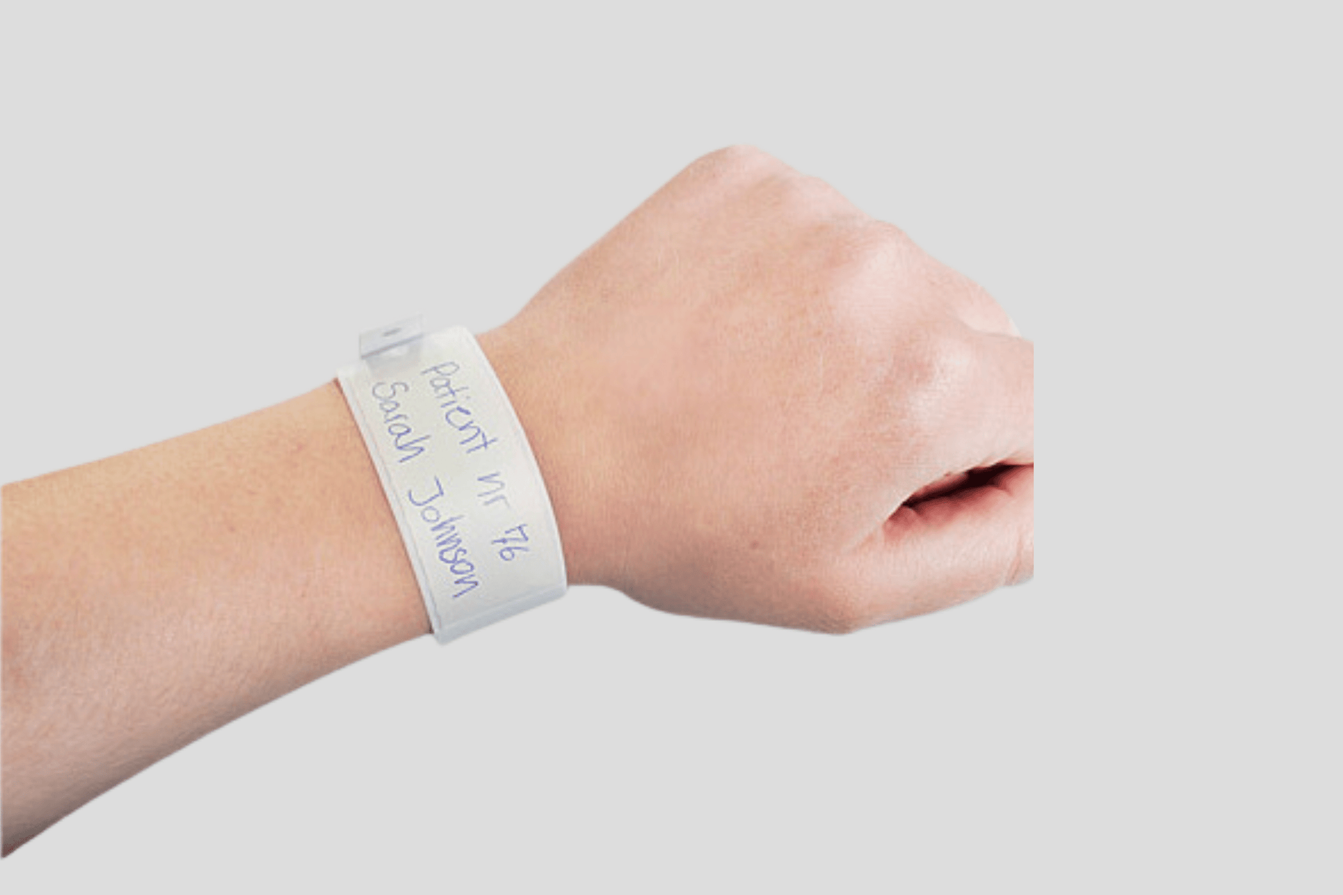 En persons håndledd med JM Band NO pasientarmbånd plastik lomme, kjent som pasientarmbånd eller sykehusarmbånd på sykehus.
