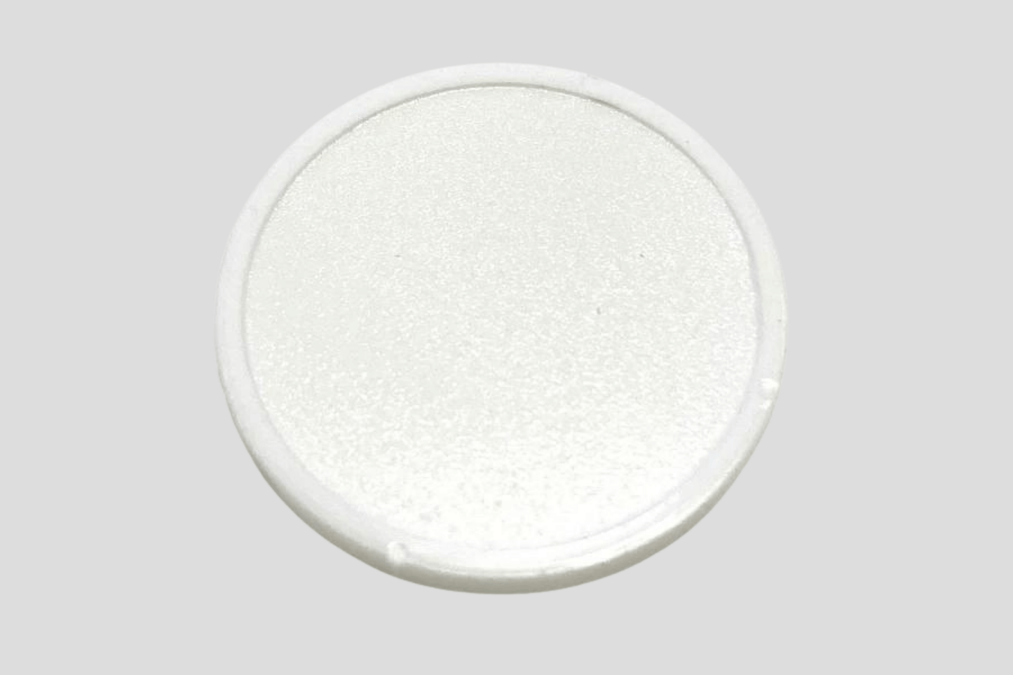 En hvit oval knapp på en grå overflate, laget av plast, kalt JM Band NOs "Poletter plast preget På lager".