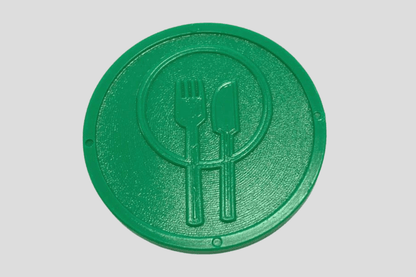 En grønn tallerken med gaffel og kniv på laget av Poletter plast preget På lager av JM Band NO.