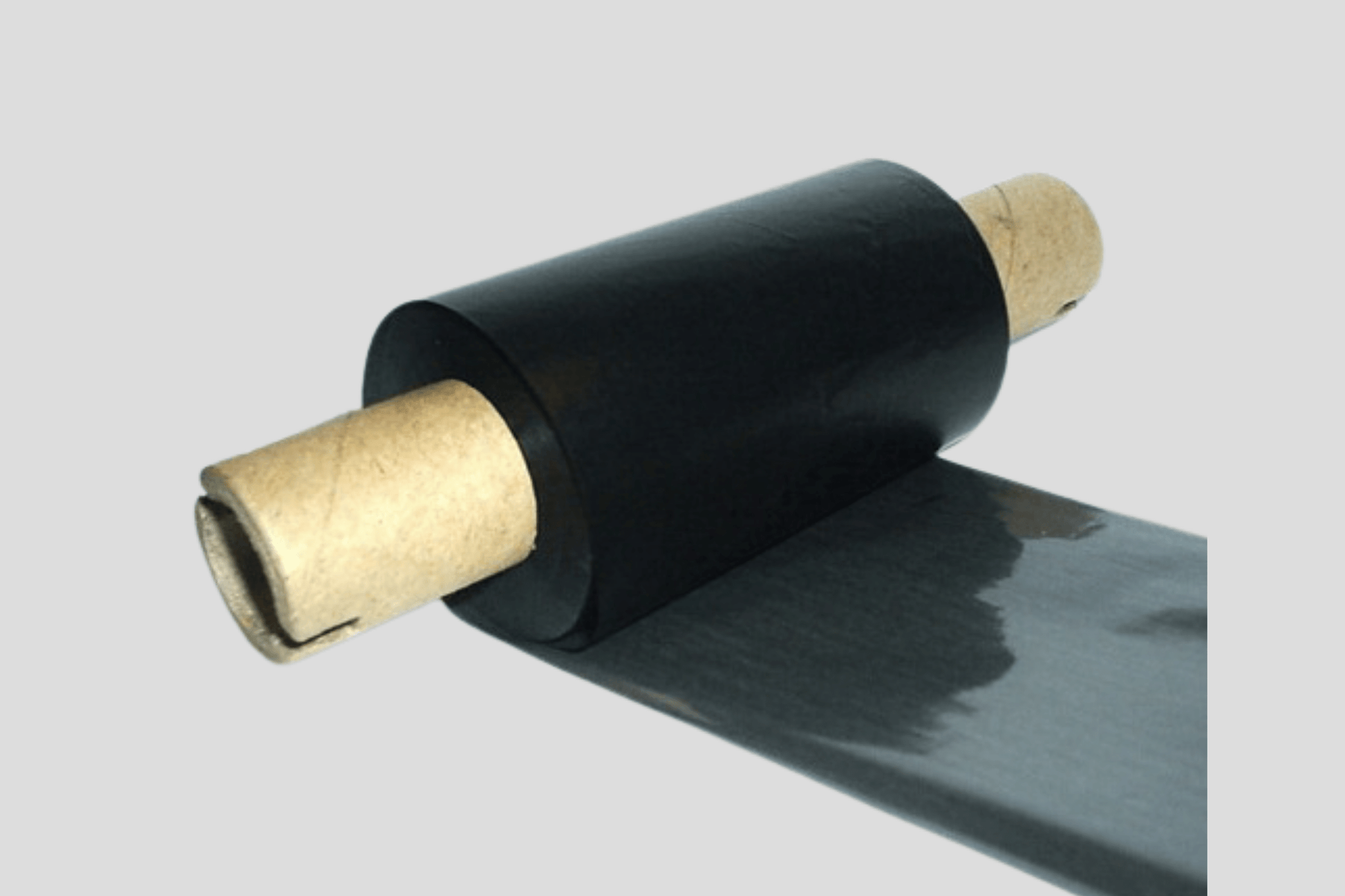 En rull med svart plasttape på hvit bakgrunn, med Folier for termiske overføring FW av JM Band NO.