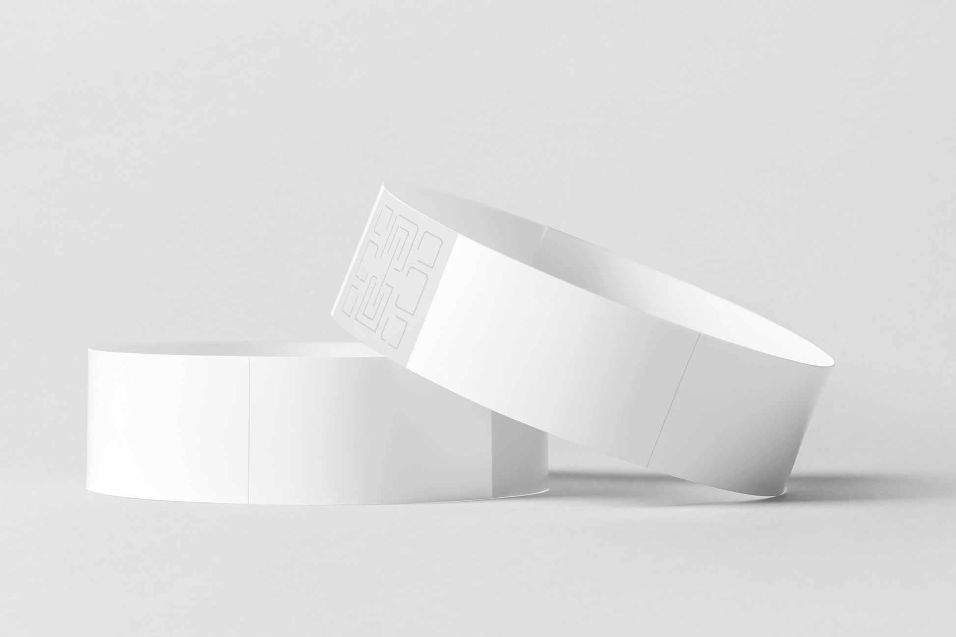 Et par Armbånd termisk - Print Selv armbånd i hvit plast på grå bakgrunn, perfekt for skrivere og termiske plast fra JM Band NO.