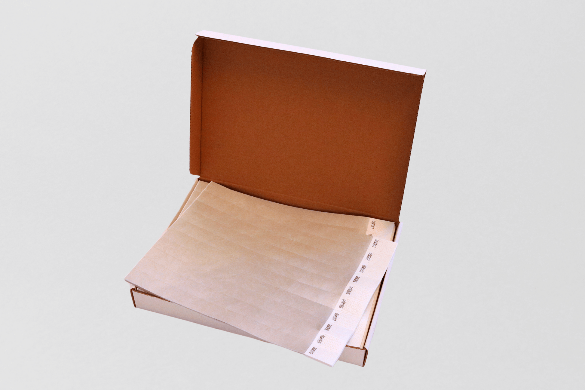 En brun boks med et ark og et JM Band NO festivalarmbånd i.
